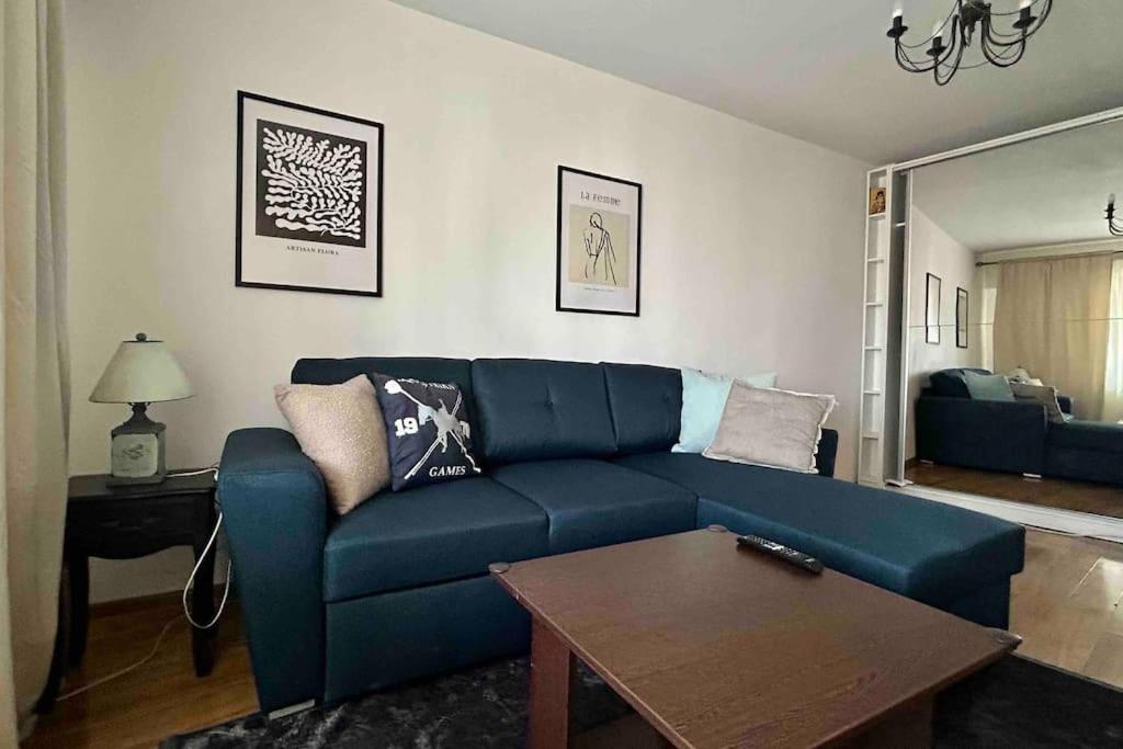 sala de estar con sofá azul y mesa en Georgiana’s central apartment, en Buzău