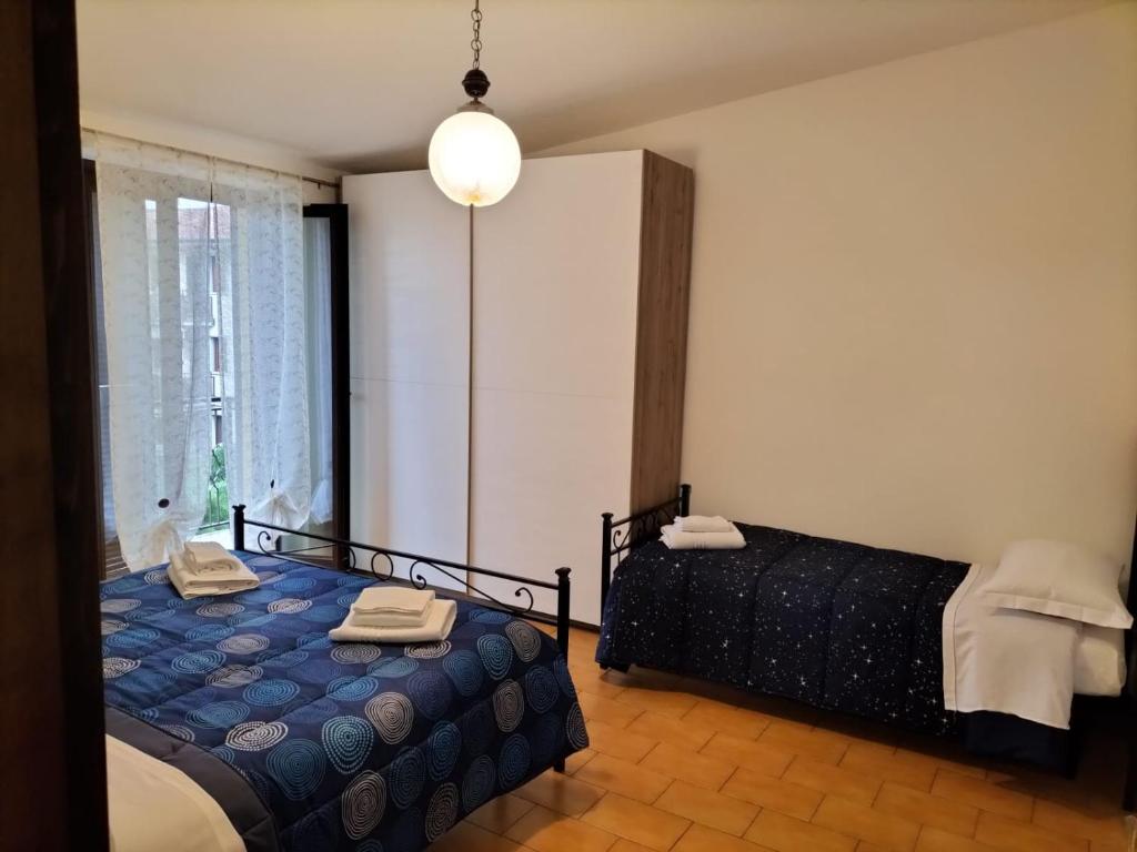 1 dormitorio con 2 camas y ventana grande en Orio easy relax 24h Airport 3 - a few steps, en Orio al Serio