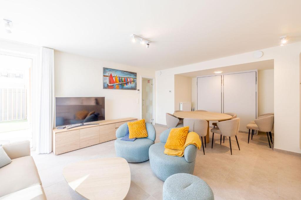 een woonkamer met een tafel en stoelen en een televisie bij Sailorshouse in Nieuwpoort