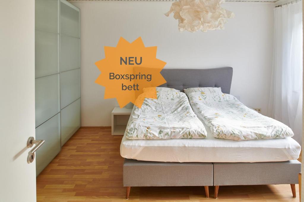a bedroom with a bed with a new browsing belt sign on the wall at Raumpause in Wegberg
