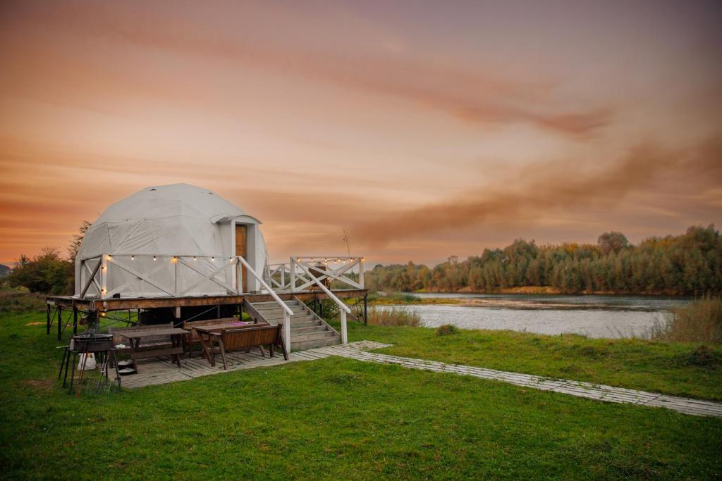 a dome tent on a dock next to a lake at Готель Еко Сфера 