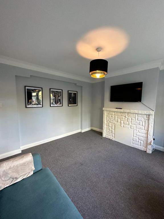 een woonkamer met een tv en een open haard bij Kenton Apartment- Wembley links in Harrow Weald