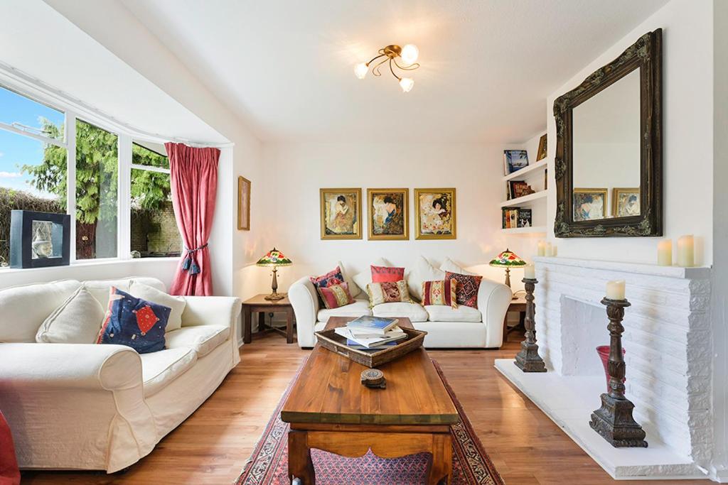 a living room with white furniture and a fireplace at Pass the Keys Hidden Cottage in Esher, West End in Esher