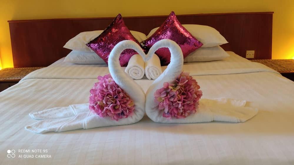Dwóch łapówek, które wyglądały jak serca na łóżku. w obiekcie the sunset view lagoon suite w mieście Pantai Cenang