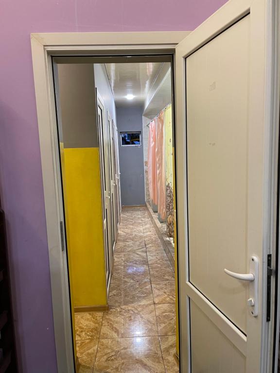 a hallway with a yellow and white door and a room at CITRUS Guest House in Yerevan