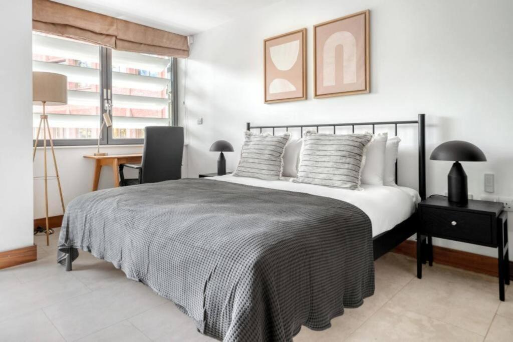 a bedroom with a bed with a desk and a chair at Exquisite 2 Bed Soho Central Apartment Sleeps 6 in London