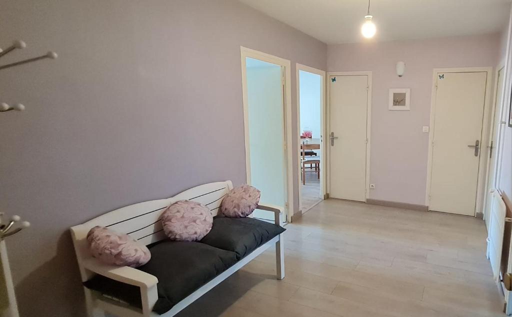 uma sala de estar com um sofá com almofadas cor-de-rosa em Appartement Meylan em Meylan