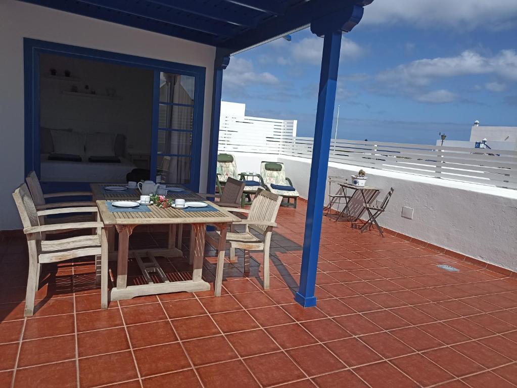 a patio with a table and chairs on a roof at Casa Rosa in Puerto Calero