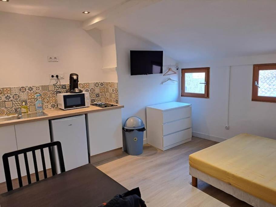 a small kitchen with a counter and a microwave at 195, studette porte d'Italie rue populaire. in Toulon