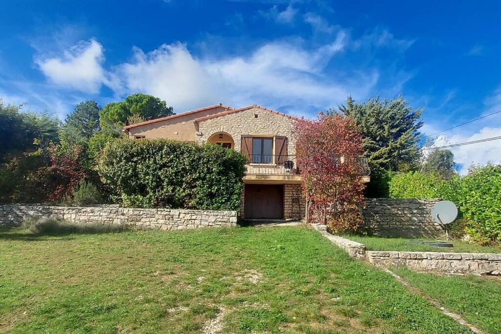 a house with a stone wall and a yard at Villa Maison de campagne 04 Vacheres Luberon 3 chambres 8 personnes in Vachères