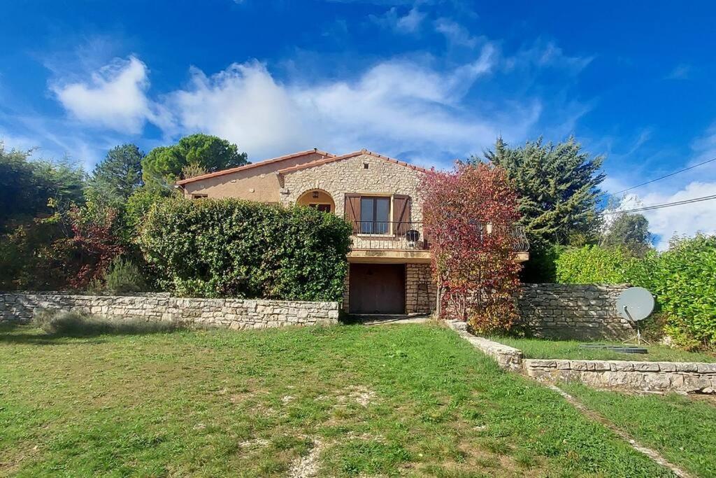 a house with a stone wall and a yard at Maison de campagne 04 Vacheres Luberon 3 chambres 8 personnes in Vachères