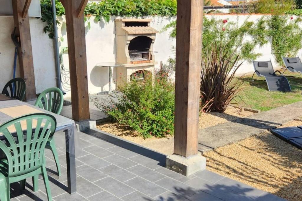 un patio avec une table et un four extérieur dans l'établissement Charmante maison 6/7 personnes., à Olonne-sur-Mer