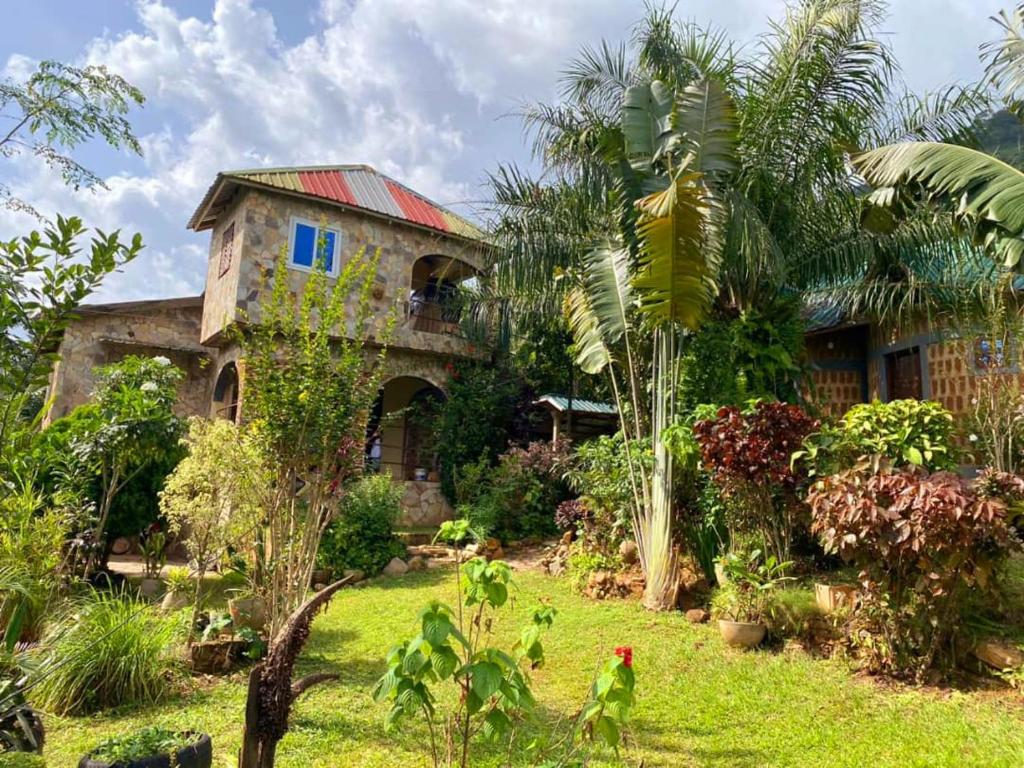 uma casa antiga com um jardim em frente em Lodge au paradis fleuri 