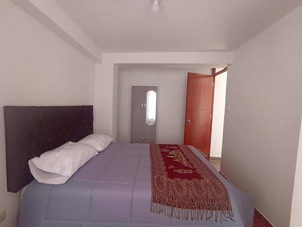 Un dormitorio con una cama con una manta roja. en La Posada del Monge en Cusco