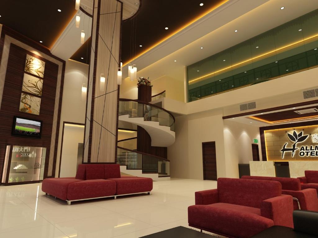 a lobby with red chairs and a spiral staircase at Hallmark Regency Hotel - Johor Bahru in Johor Bahru