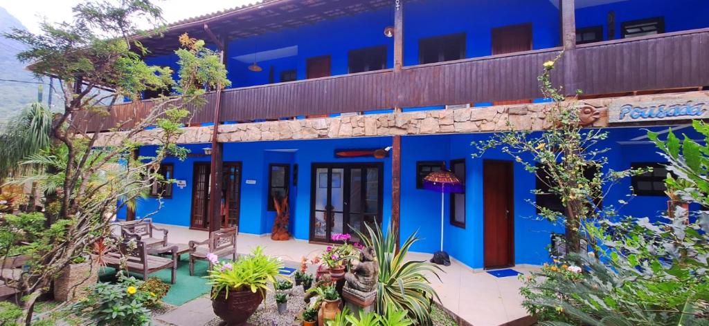 un edificio blu con piante davanti di Pousada dos Meros a Abraão