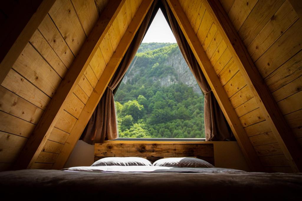 Šavnik的住宿－Natures Escape Kozarica，一张位于带大窗户的房间内的床铺