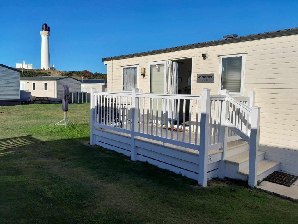 uma casa móvel com uma escada e um farol em hollies retreat em Lossiemouth