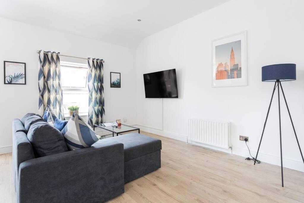 een woonkamer met een bank en een tv bij Top Floor, City Centre, Parking in Belfast