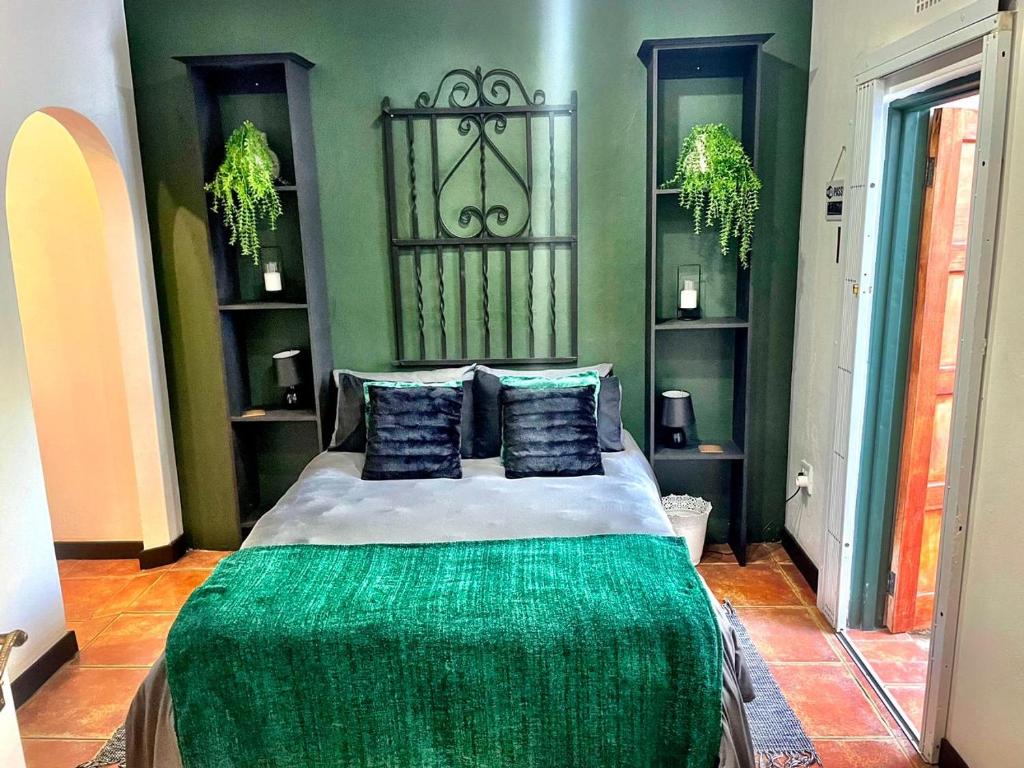 a bedroom with a bed with a green blanket on it at Starlight Stay in Groblersdal