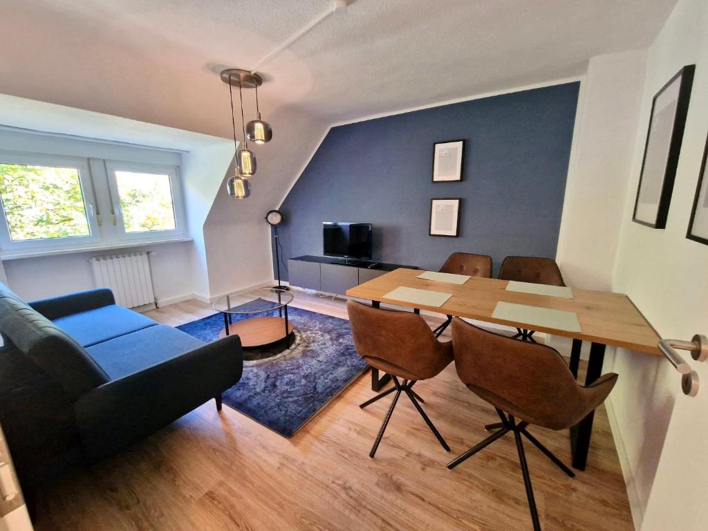 - un salon avec une table à manger et un canapé dans l'établissement Bis 4 Pers. 0,3 km zur City von Wuppertal – neuwertige Wohnung, à Wuppertal