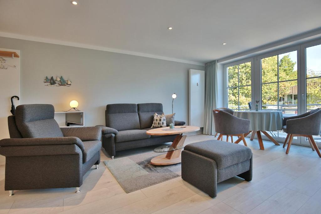 - un salon avec un canapé, des chaises et une table dans l'établissement Haus Schäfer, à Timmendorfer Strand
