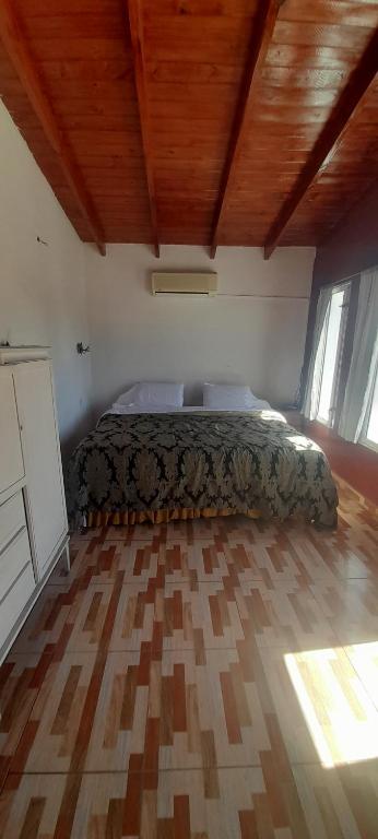 1 dormitorio con cama y techo de madera en Alojamiento walter en Ezeiza