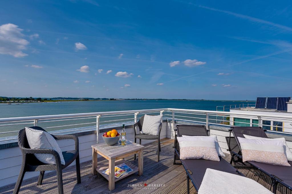 a balcony with chairs and a table on a cruise ship at Ferienhaus Nordlicht Olpenitz in Olpenitz