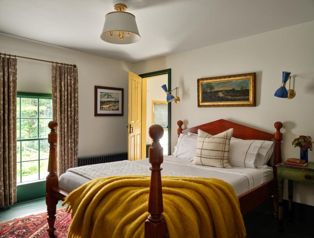 a bedroom with a bed with a yellow blanket on it at The Ell, a Historic, Luxurious 2 bed, 2 bath Private Suite in Lovell in Lovell