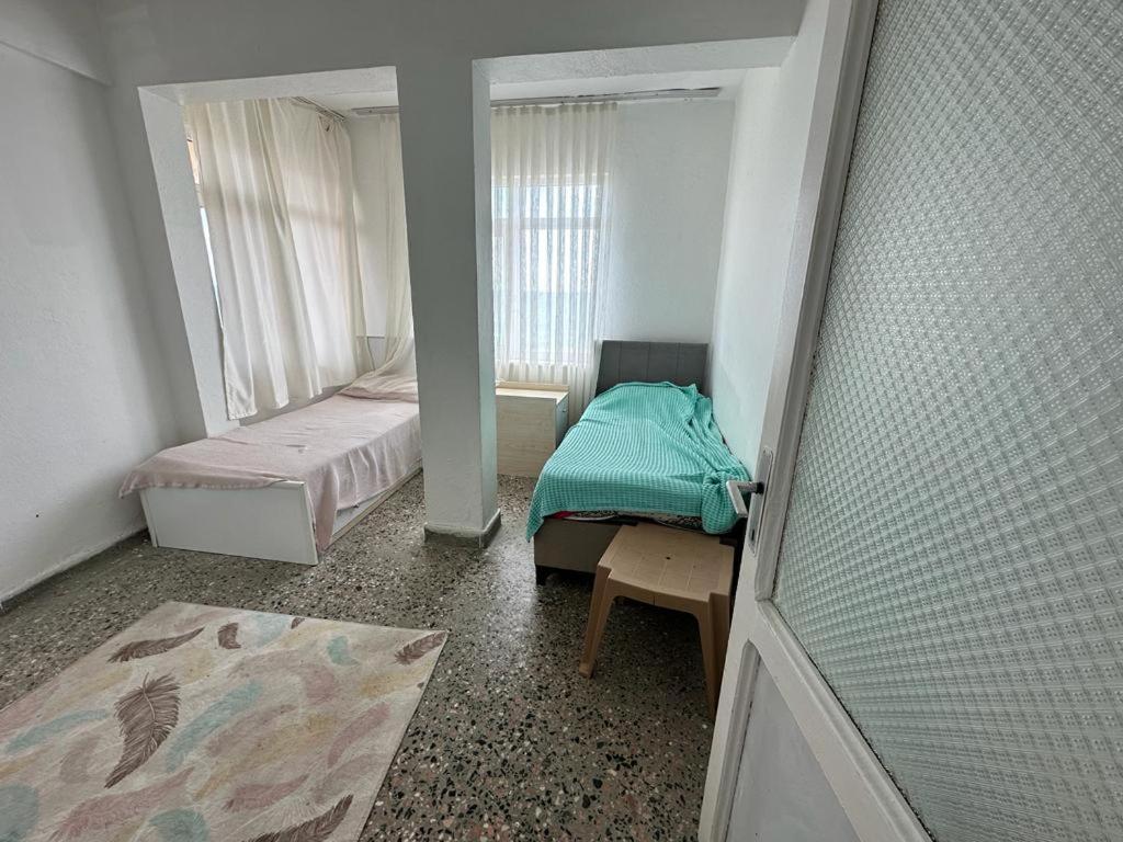 Cette petite chambre comprend 2 lits et une fenêtre. dans l'établissement DENİZ YILDIZI, à Marmaraereglisi