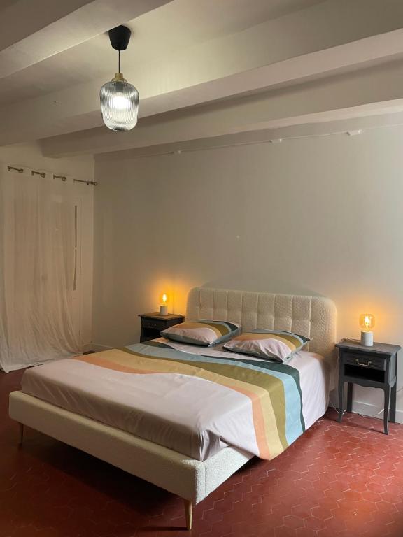 ein Schlafzimmer mit einem Bett mit zwei Nachttischen und zwei Lampen in der Unterkunft Sole Mia, appt 2/4pers au cœur de Bormes in Bormes-les-Mimosas
