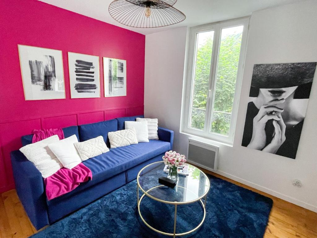 - un salon avec un canapé bleu et des murs roses dans l'établissement Maison Yuki - Rose Velours - Netflix & Parking, à Le Mont-Dore
