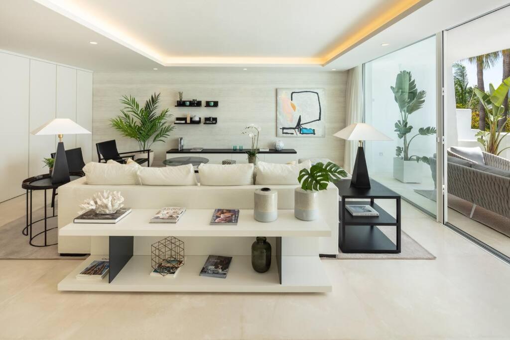a living room with a white couch and a table at Stunning Duplex Apartment in Puente Romano Resort in Marbella