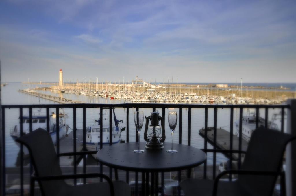 a table and chairs on a balcony with a marina at ''Luigi'' BALCON SUR LA MER et le Port de Sète in Sète