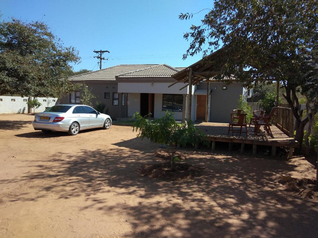 a car parked in front of a house at Chobe Blue Guest Inn in Kasane