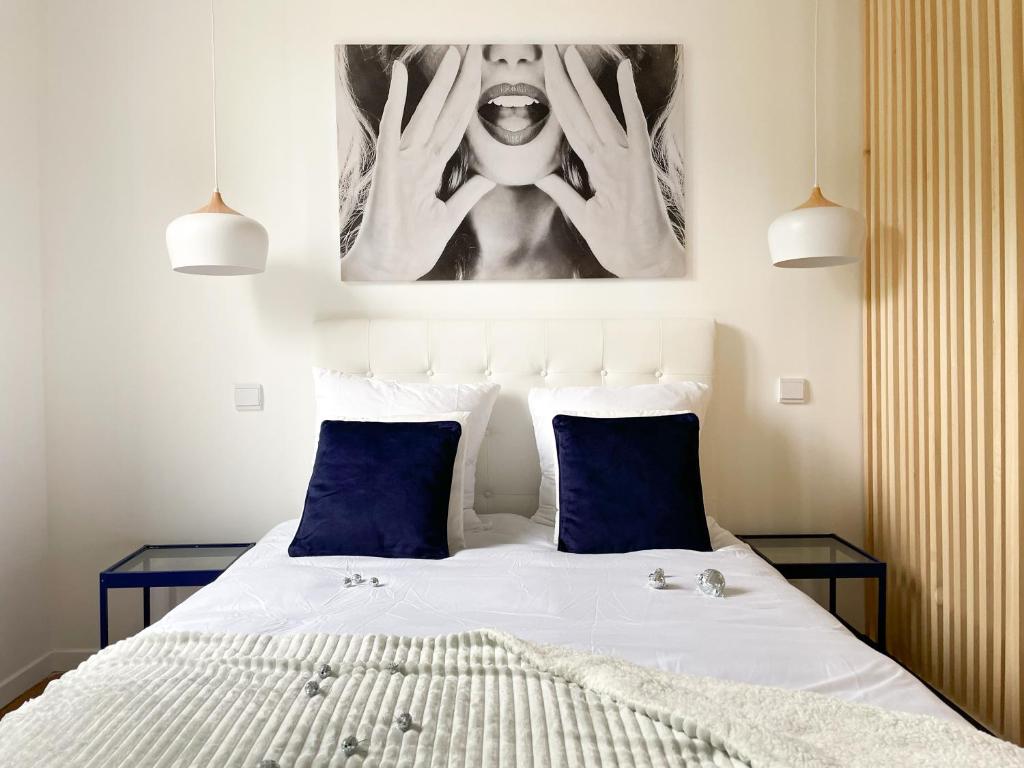 a bedroom with a bed with two blue pillows at Appartement Rose velours in Le Mont-Dore