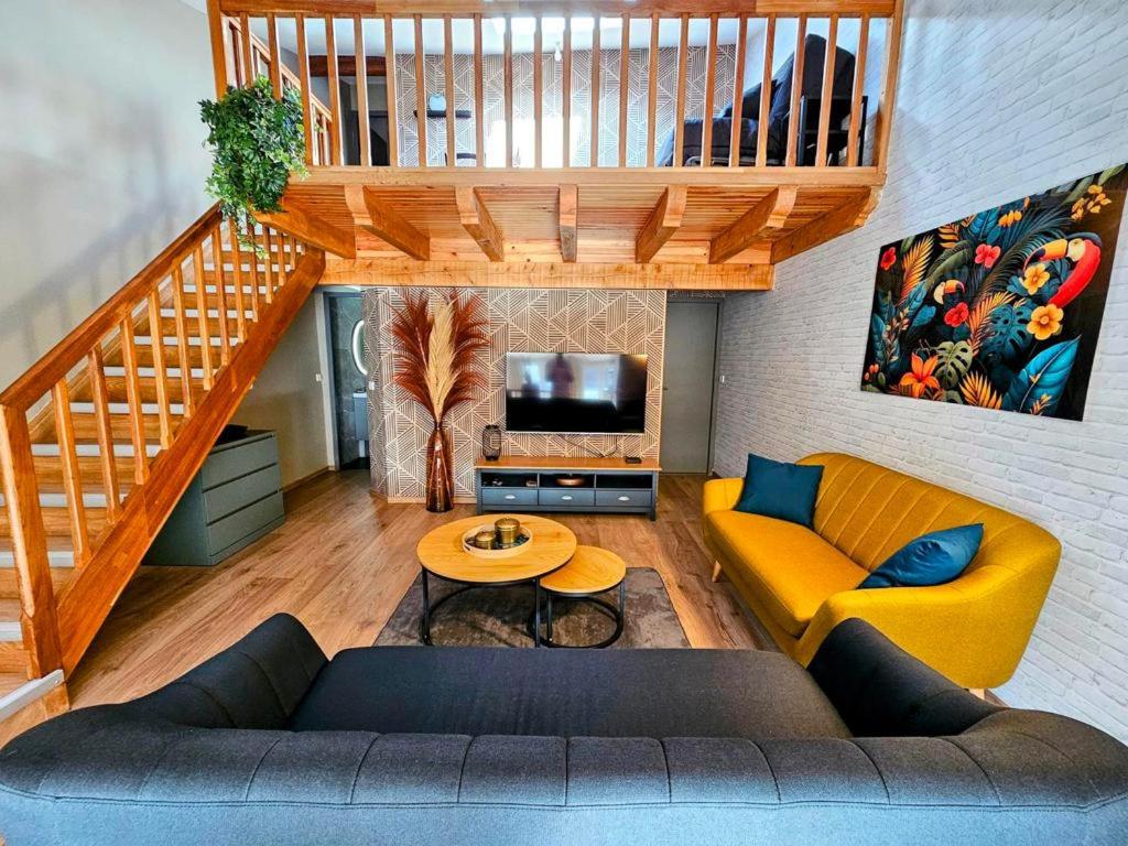 ein Wohnzimmer mit einem Sofa und einem Tisch in der Unterkunft Le Cottage du Château 