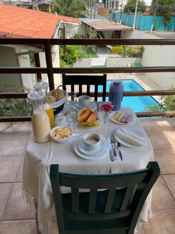 uma mesa com comida e vista para uma piscina em Flat ACM em Natal