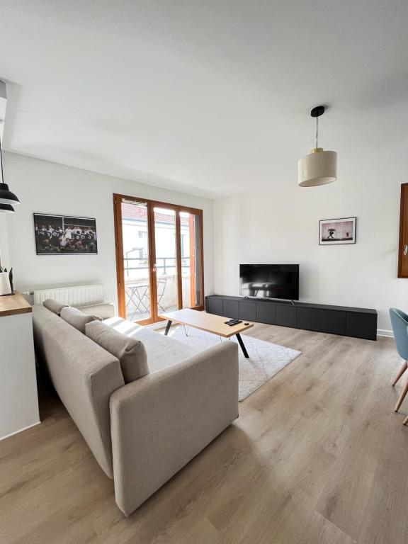 a living room with a couch and a table at Appartement Porte de Paris / Stade de France in Saint-Denis