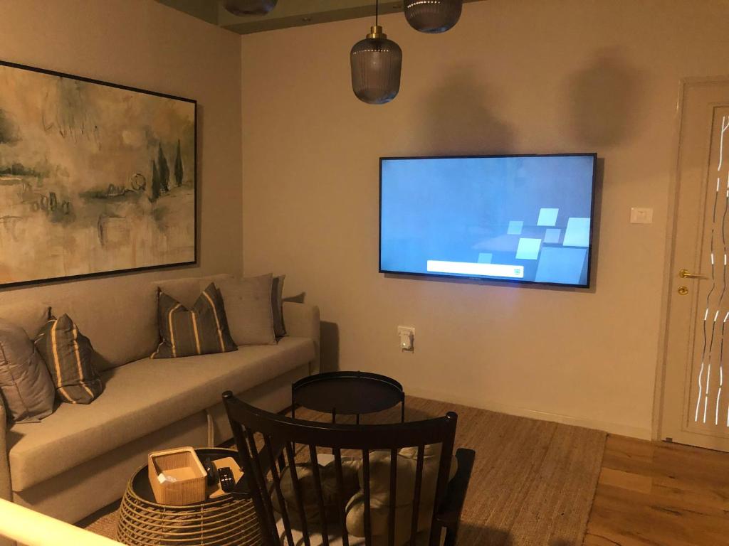 sala de estar con sofá y TV de pantalla plana en סוויטה על שביל הים en Atlit