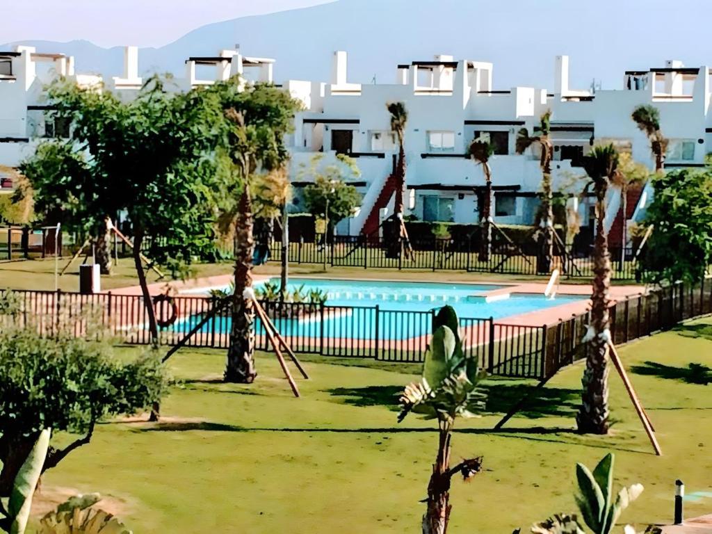 a woman sitting on a swing in front of a pool at Cozy Pool & Golf House at Condado de Alhama 