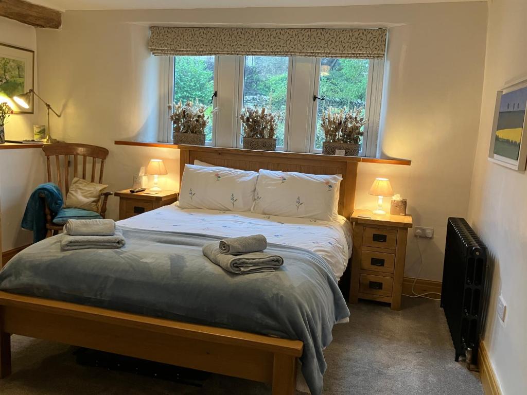 a bedroom with a bed with two towels on it at The Wharfe at Greystones - Cosy, comfortable retreat in Buckden