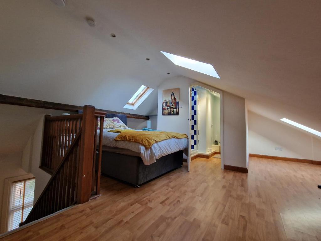ein Schlafzimmer mit einem Bett und eine Treppe mit Oberlichtern in der Unterkunft CosyHomeStay Evesham Spacious home W/Free Parking & WiFi in Evesham