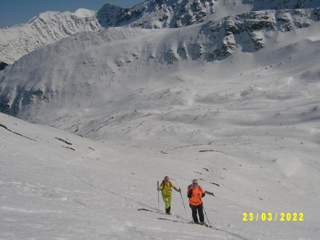 two people skiing on a snow covered mountain at Apartmány Grobarčík in Zuberec