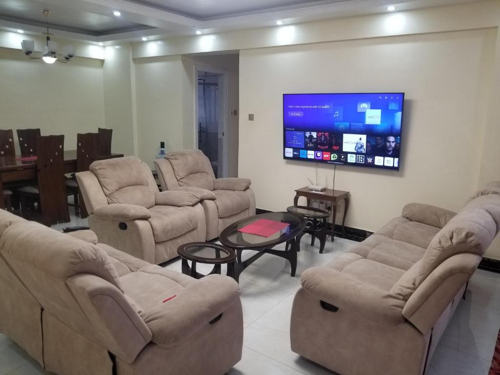 sala de estar con sofás y TV de pantalla plana. en JVhomes2bedroom-Ndemi gardens en Nairobi