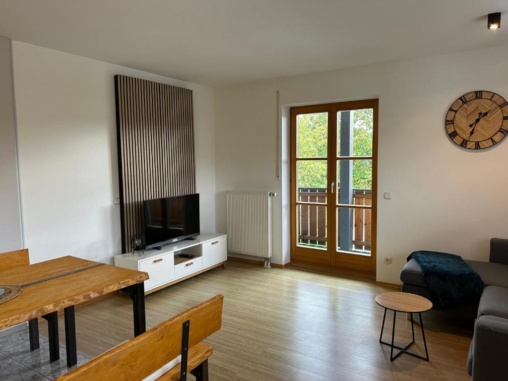een woonkamer met een bank, een tv en een tafel bij Gehobene Ferienwohnung Madera Campesina in Hunderdorf