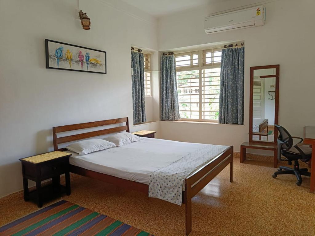a bedroom with a bed and a desk and a chair at Srinekatan Heritage Villa Homestay in Ahmedabad