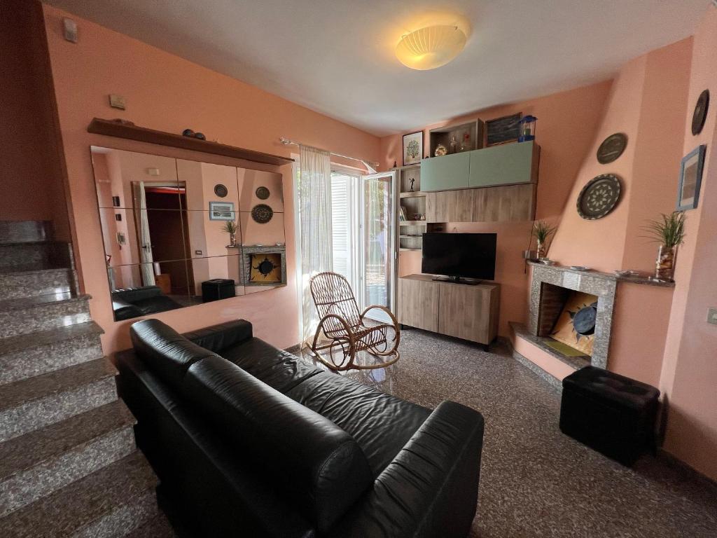 ein Wohnzimmer mit einem Sofa und einem Kamin in der Unterkunft Casa al mare con giardino vicino a Roma in Torvaianica