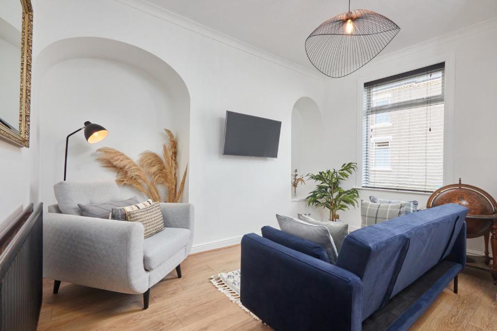 a living room with a blue couch and two chairs at The Derwent in Darlington