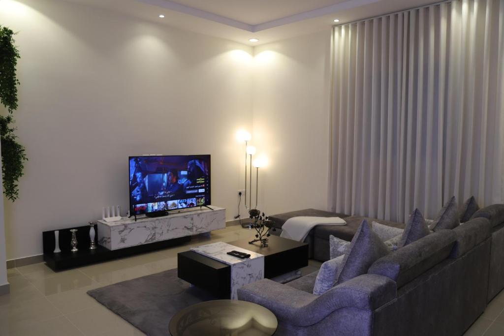 a living room with a couch and a tv at Zaan Apartment Al-Nafel in Riyadh